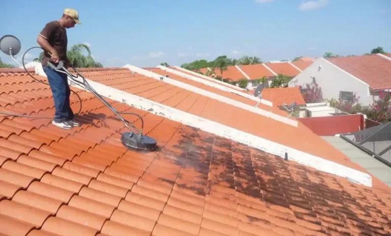 Homme sur un toit qui enlève la mousse de la toiture